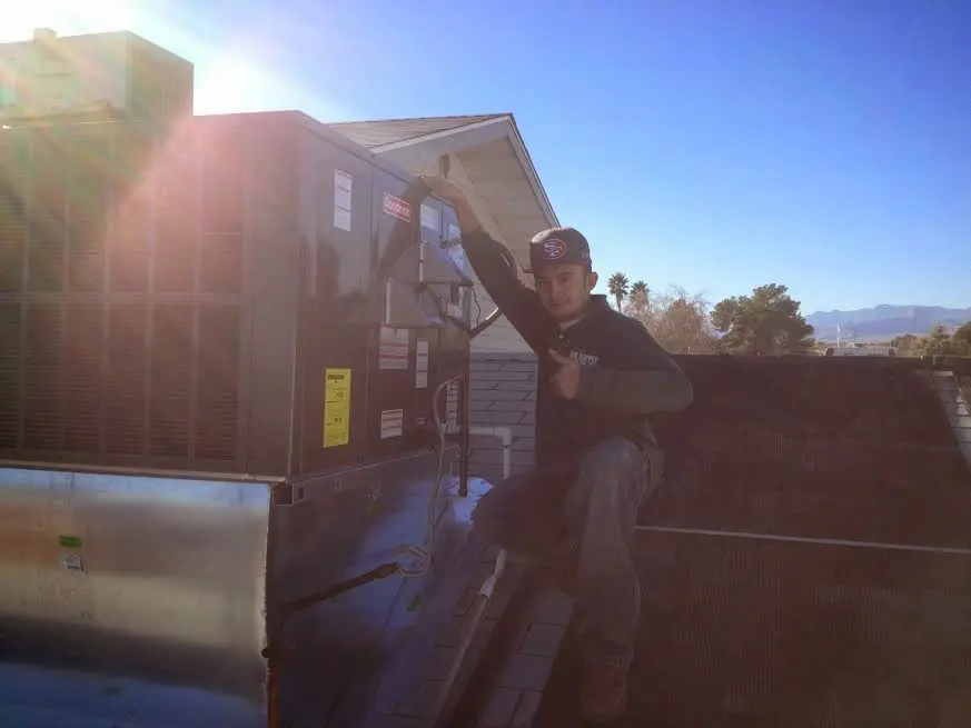 HVAC technician performing Heat Pump Repair on a rooftop unit in Channelview